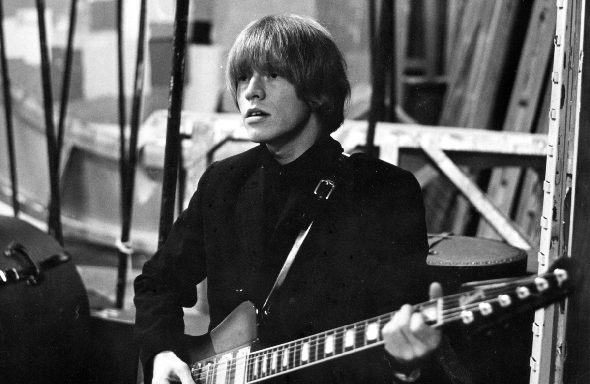 Brian Jones des Rolling Stones joue de la guitare sur scène.