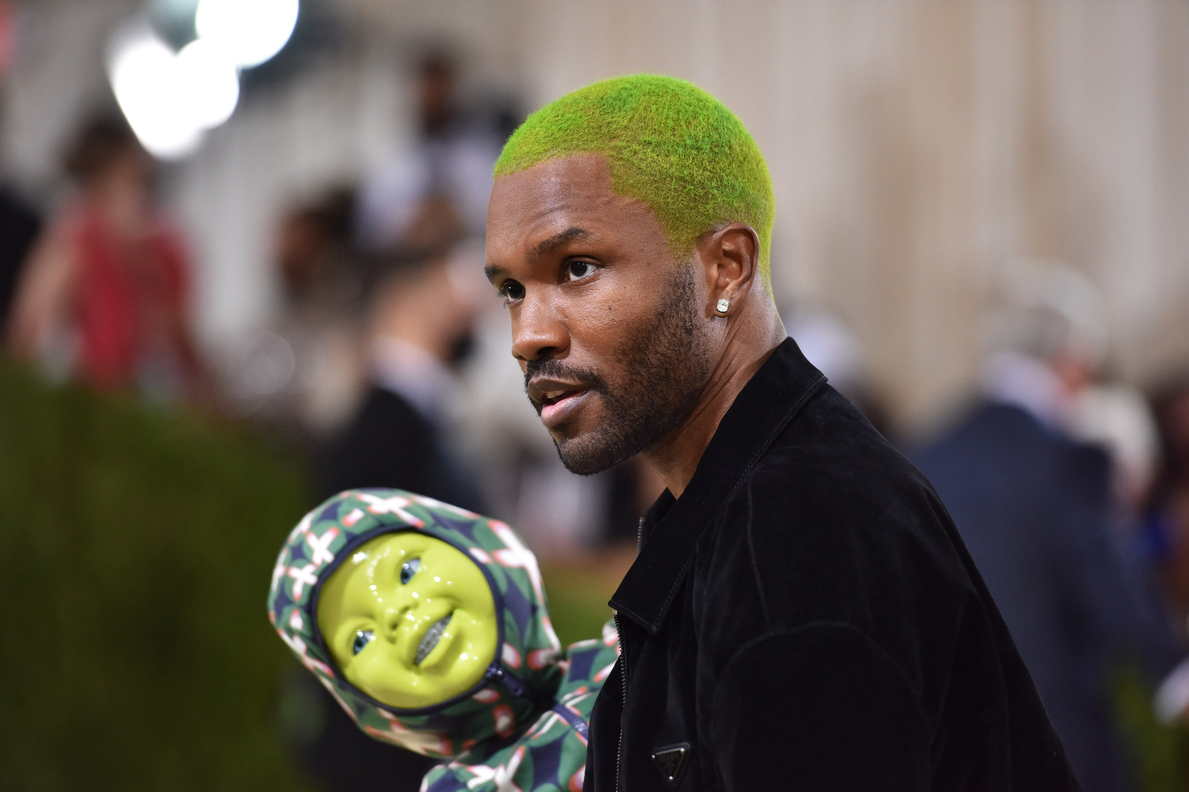 Frank Ocean, qui écrit et réalise actuellement un film avec A24, porte un costume noir et tient une poupée verte