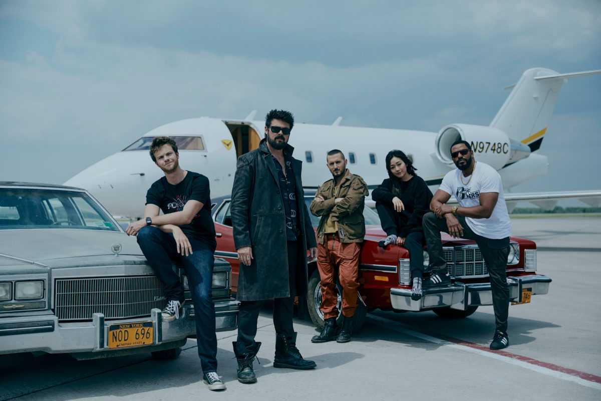 Jack Quaid (Hughie Campbell), Karl Urban (Billy Butcher), Tomer Capone (Frenchie), Karen Fukuhara (Kimiko), Laz Alonso (Mother's Milk) debout devant un avion dans une image de la saison 3 de 