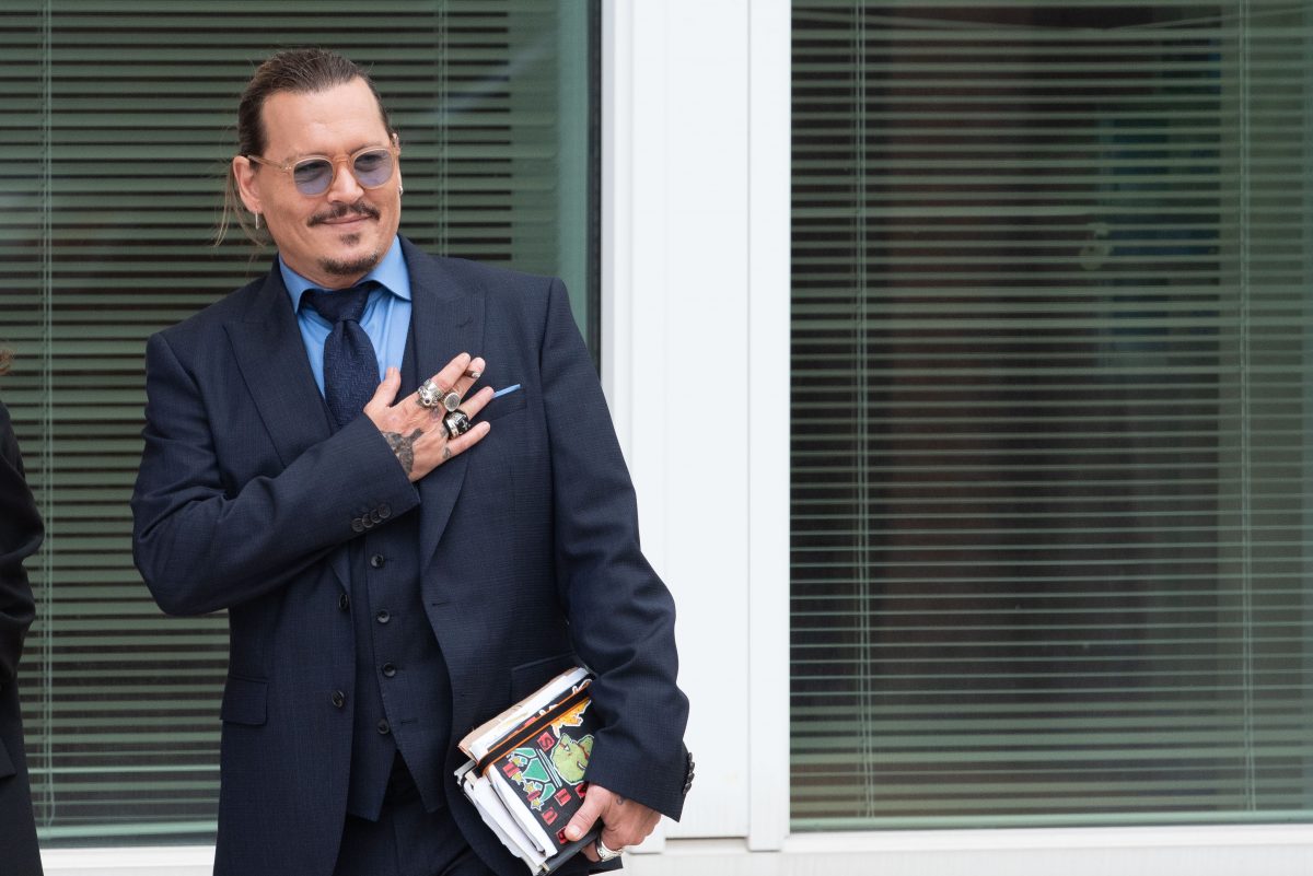 La star de Pirates des Caraïbes Johnny Depp salue les fans devant le palais de justice de Fairfax lors d'une suspension du procès en diffamation contre Amber Heard, qui vient de rendre un verdict favorable à Depp