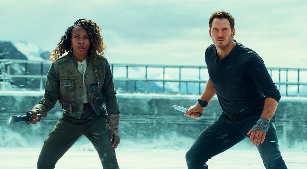 'Jurassic World Dominion' DeWanda Wise dans le rôle de Kayla Watts tenant un bâton électrique et Chris Pratt dans le rôle d'Owen Grady tenant un couteau, prêt à se battre dans un paysage de neige.