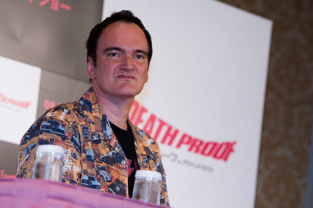 Quentin Tarantino, qui, selon les fans, a un fétichisme des pieds, portant une chemise boutonnée sur un panneau