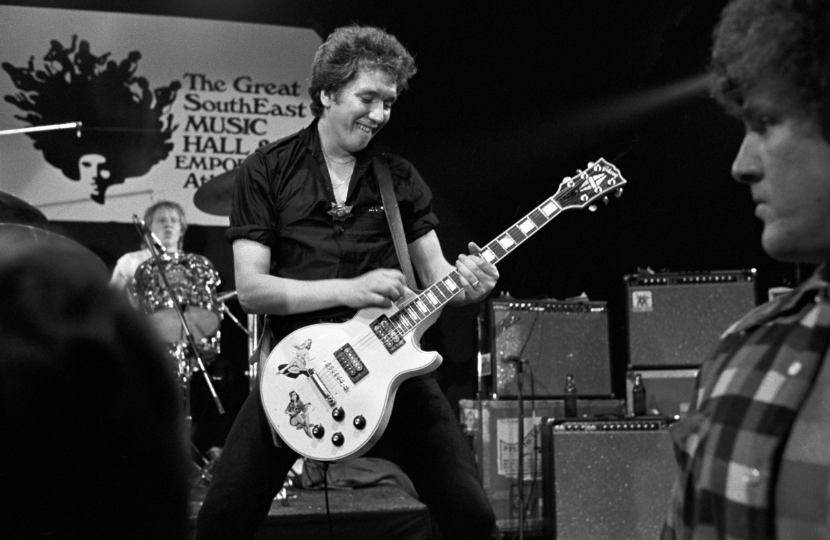 Steve Jones joue de la guitare sur scène en tant que membre des Sex Pistols.