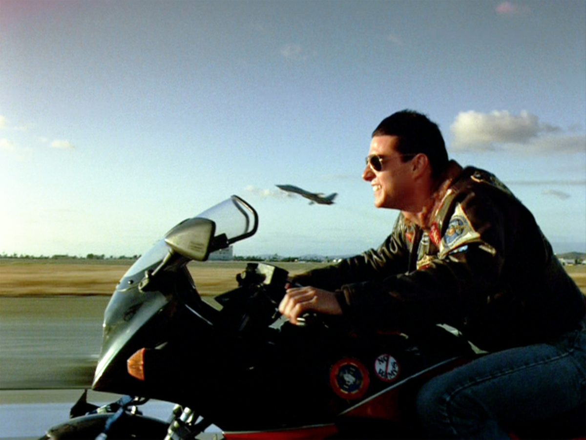 Tom Cruise apparaît en tant que Maverick dans Top Gun de Tony Scott, qui comprend la scène emblématique du volleyball de plage