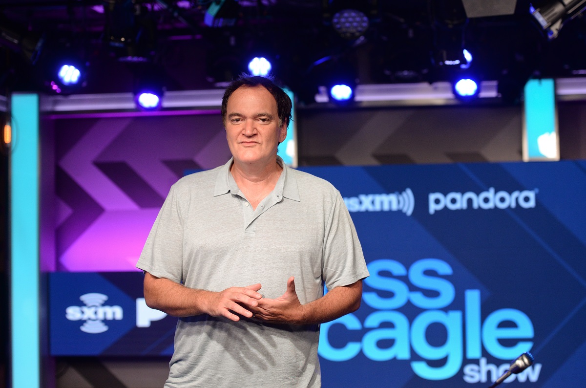 Quentin Tarantino pose en portant une chemise bleue.