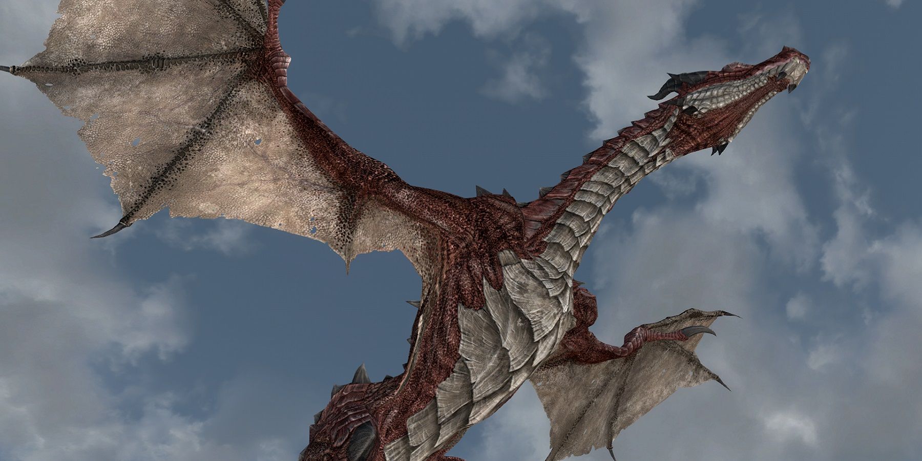 Image de Skyrim montrant le dessous d'un dragon qui vole majestueusement dans les airs.