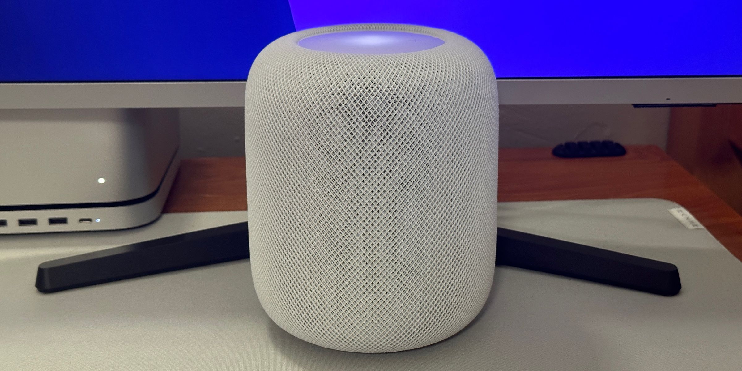 Un HomePod blanc de deuxième génération sur un bureau. 