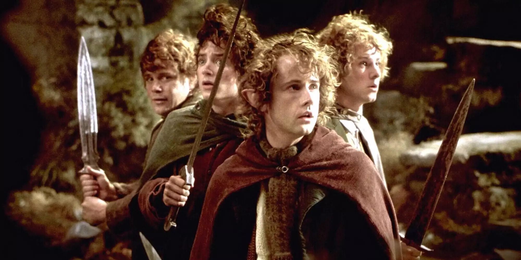 Hobbits Frodon, Sam, Merry et Pippin tenant des épées sur Weathertop dans 'Le Seigneur des Anneaux : La Communauté de l'Anneau'
