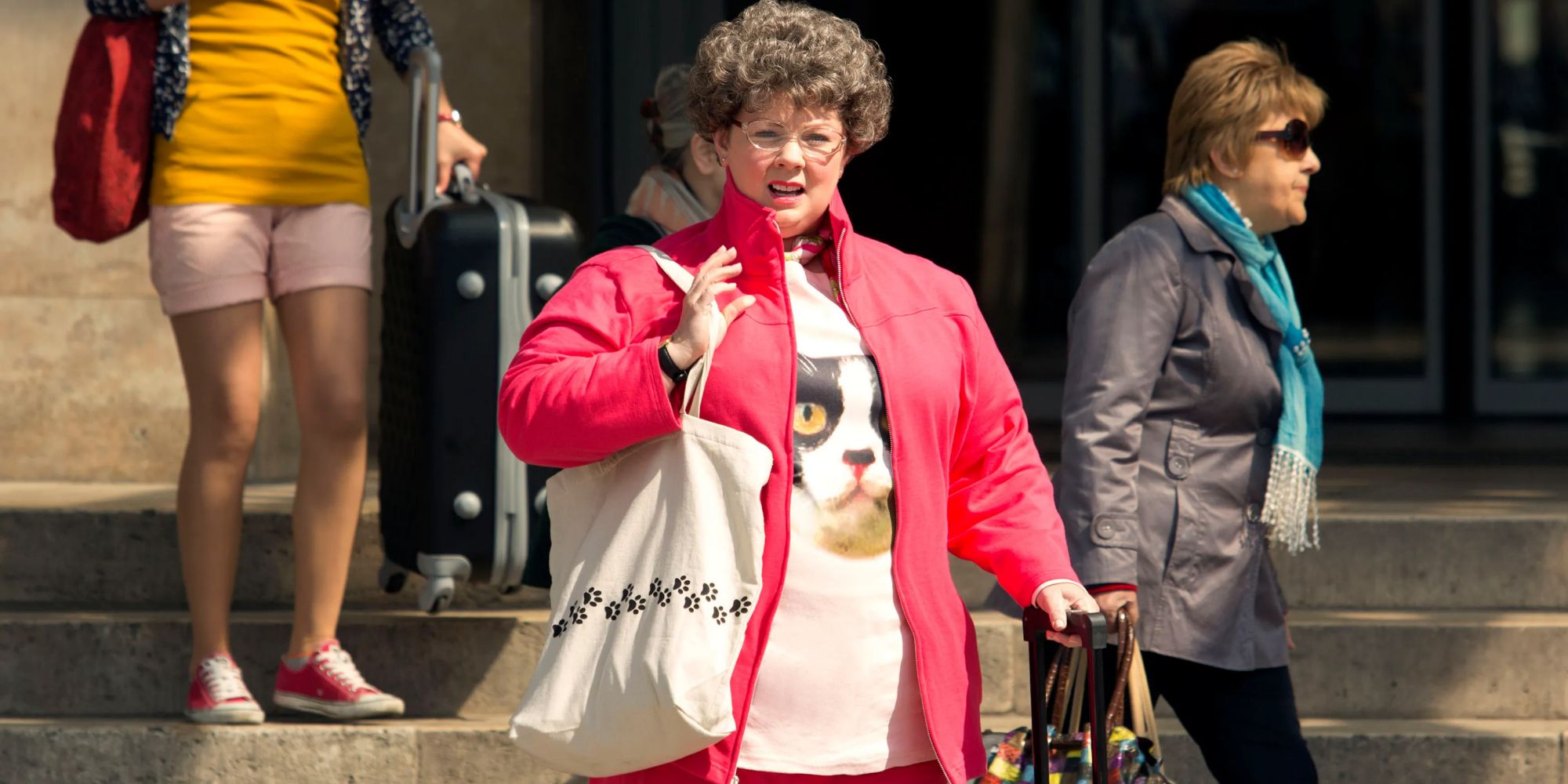 Susan vêtue d'une tenue laide debout sur un trottoir regardant au loin dans Spy.