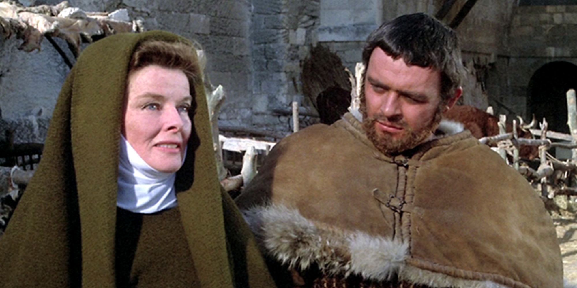 Katharine Hepburn debout à côté d'Anthony Hopkins parlant alors qu'il la regarde dans Le Lion en hiver