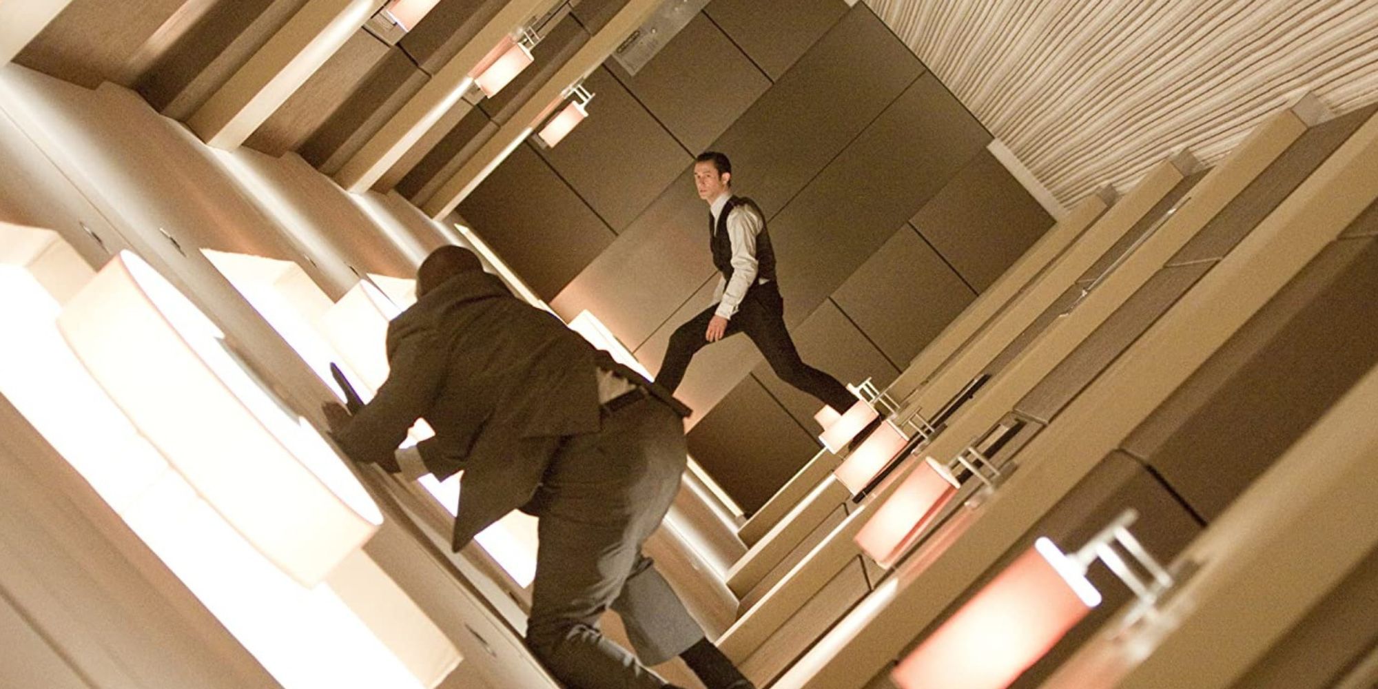 Joseph Gordon-Levitt dans le rôle d'Arthur combattant un homme dans un couloir en rotation dans Inception
