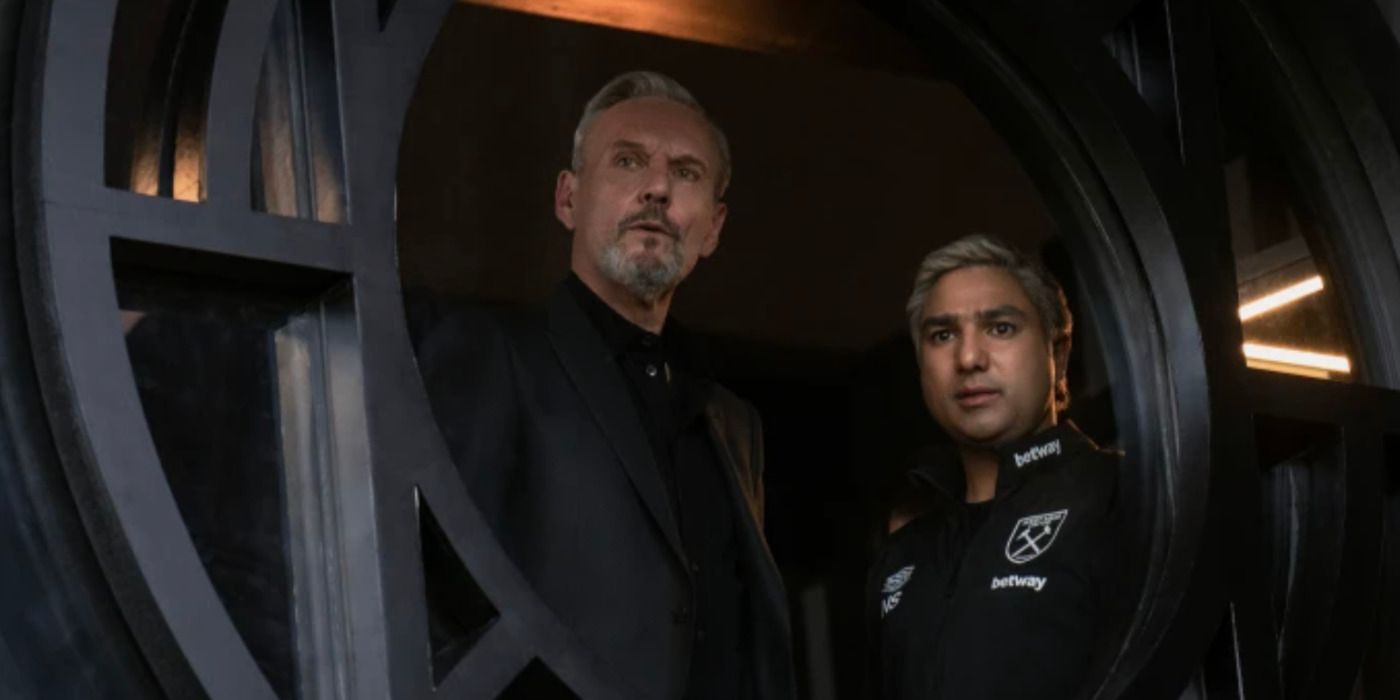 Anthony Head dans le rôle de Rupert et Nick Mohammed dans le rôle de Nate regardant par la fenêtre du bureau de Rupert dans la saison 3 de Ted Lasso