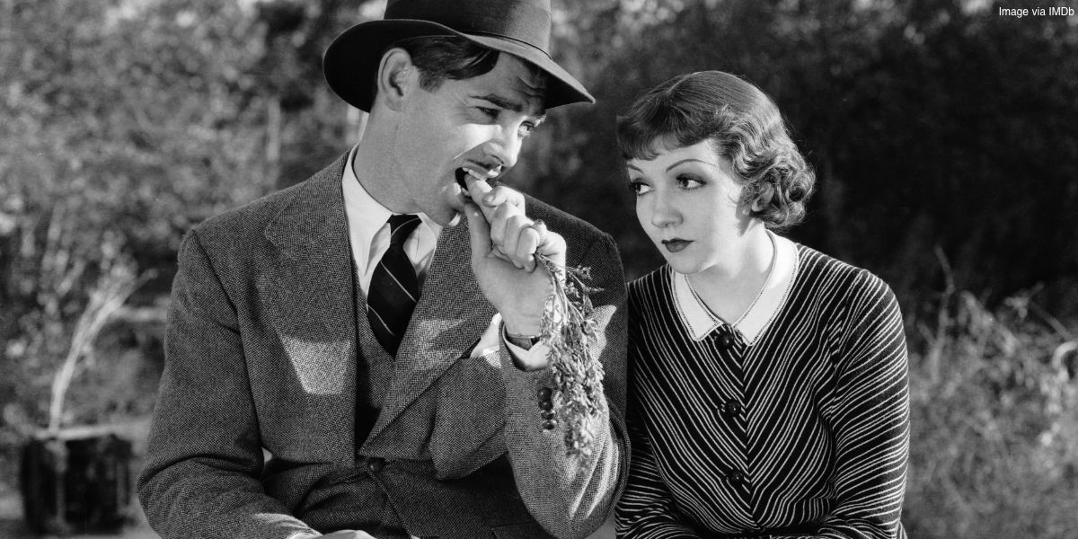 Clark Gable mangeant une carotte assis à côté de Claudette Colbert dans It Happened One Night
