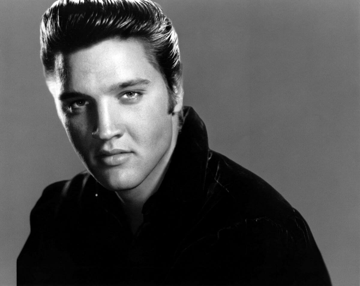 Une photo en noir et blanc d'Elvis Presley portant une chemise avec un col.
