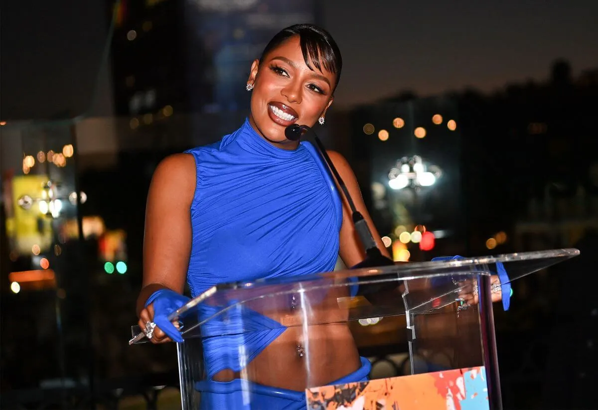 Victoria Monet porte une robe bleue et monte sur un podium lors des prix ASCAP.