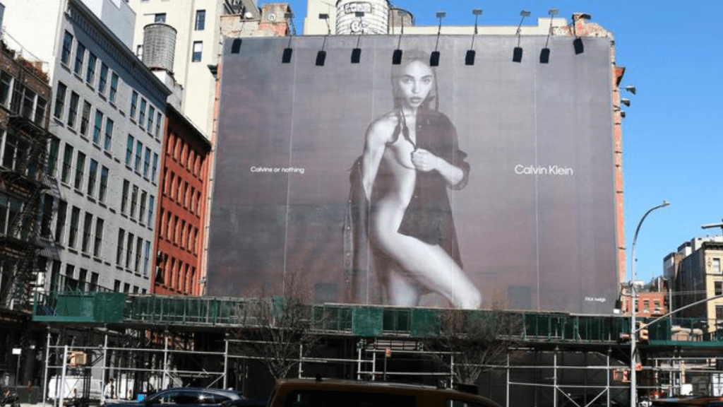 Panneau d'affichage sur le côté d'un immeuble montrant des brindilles de FKA portant une chemise Calvin Klein