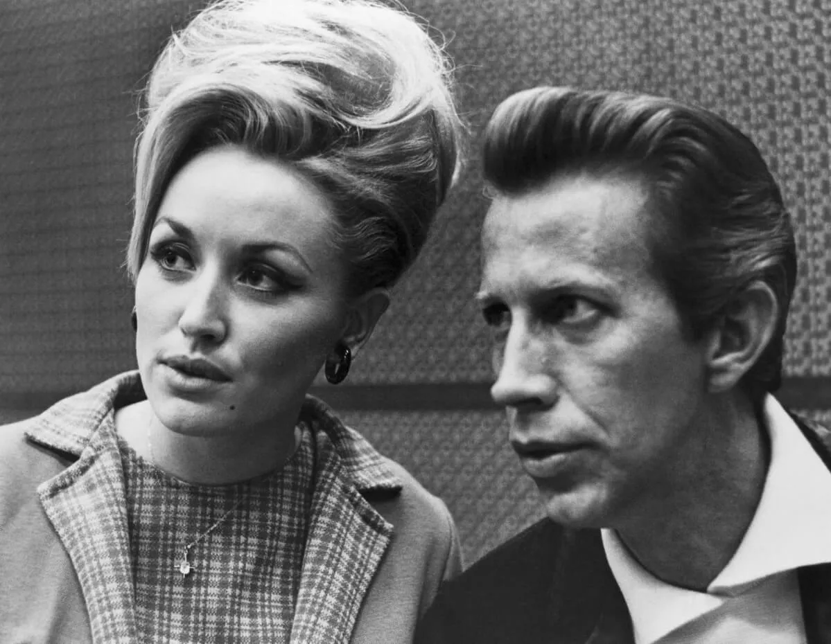 Une image en noir et blanc de Dolly Parton et de Porter Wagoner assis ensemble.