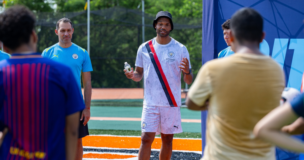 L'alun de Manchester City, Joleon Lescott, et notre ville dans les entraîneurs communautaires organisent une clinique au George Washington Educational Campus à Washington Heights.