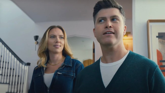 Scarlett Johnansson regarde Colin Jost alors qu'ils se tiennent dans un salon.