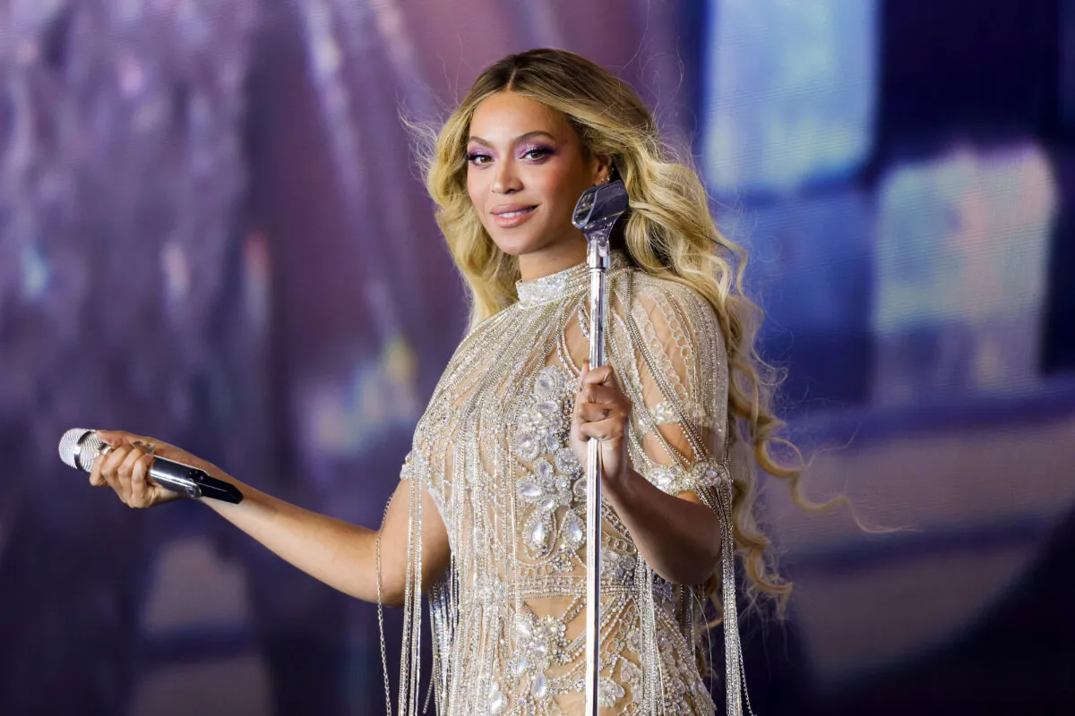 Beyoncé porte un body blanc et tient un micro.