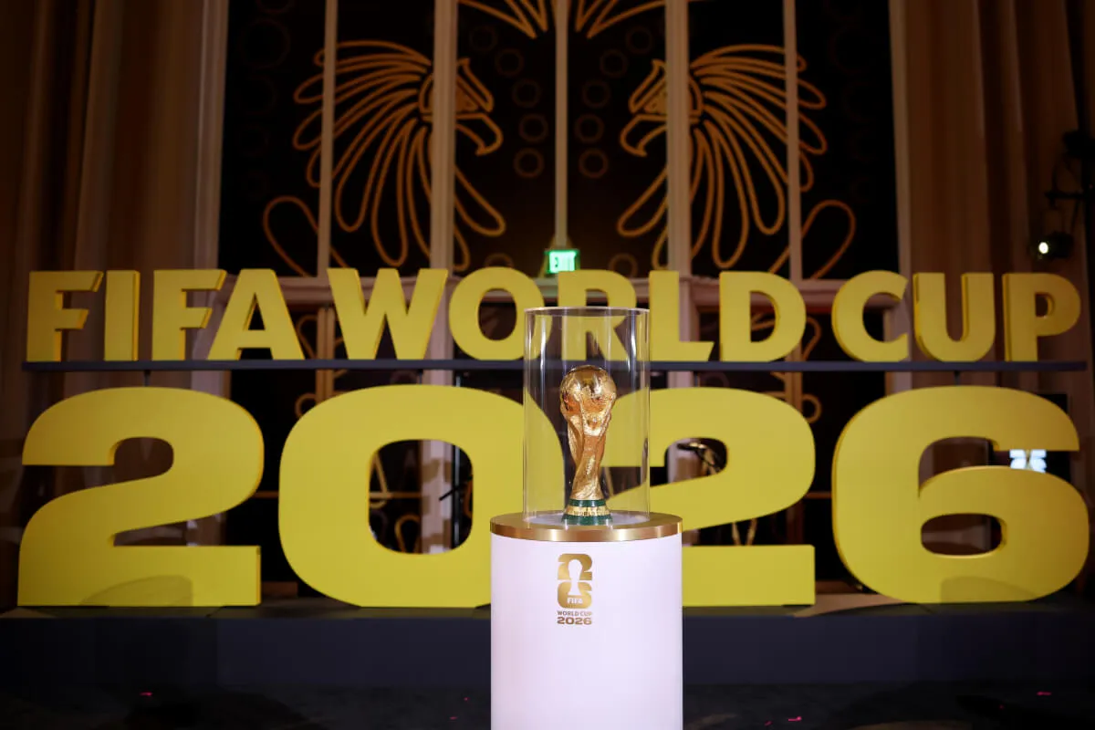 Le trophée de la Coupe du Monde de la FIFA est enfermé dans du verre devant le texte "COUPE DU MONDE FIFA 2026."