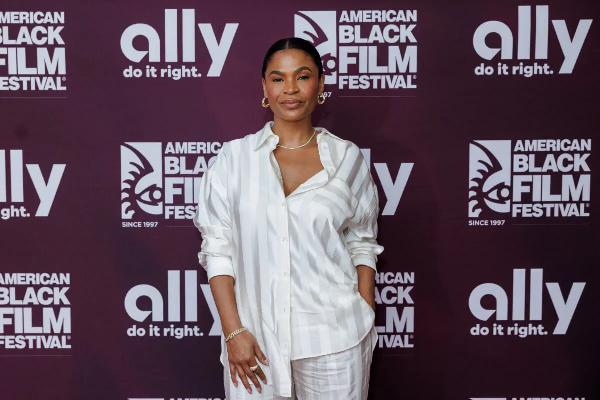 Nia Long porte une chemise blanche et un pantalon blanc assorti.